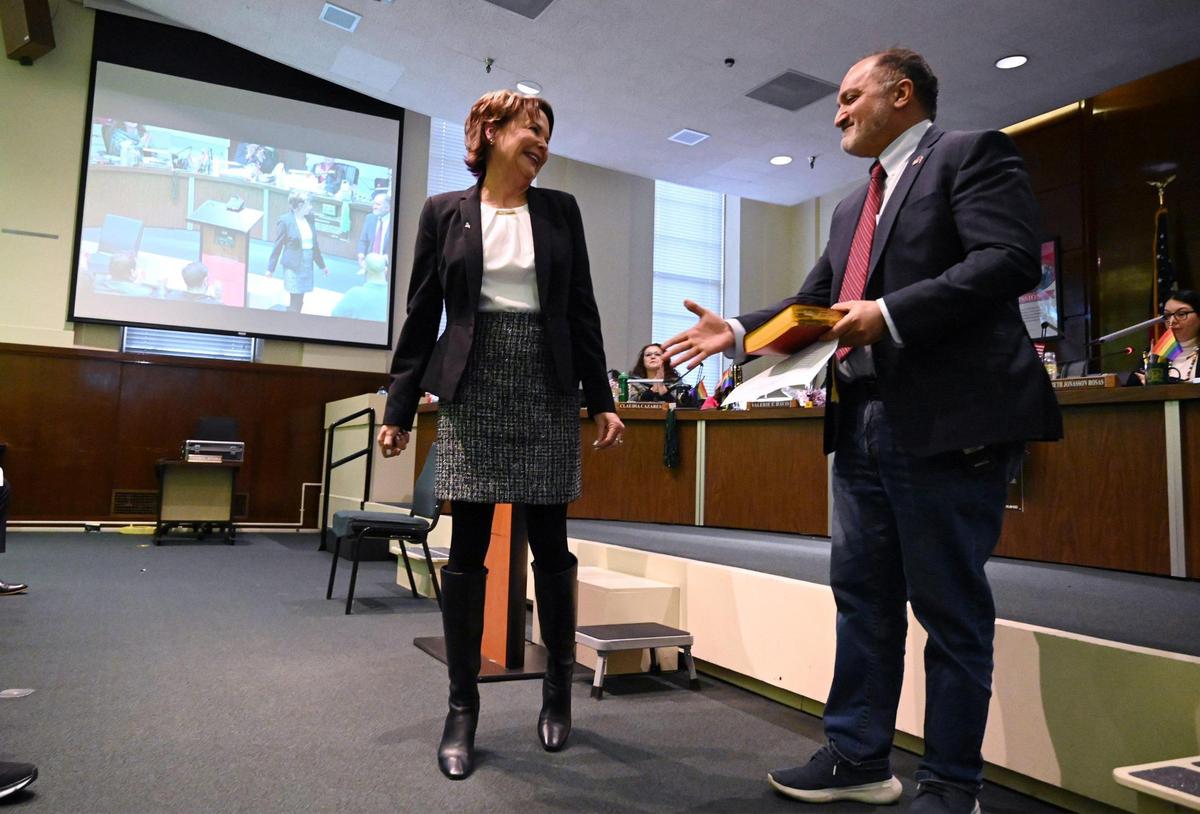 Newly elected school board trustee Susan Wittrup, left, is seen after being sworn-in by her boyfriend Darius Assemi, right, at a ceremony held in the FUSD board room Wednesday, Dec. 14, 2022 in Fresno.
