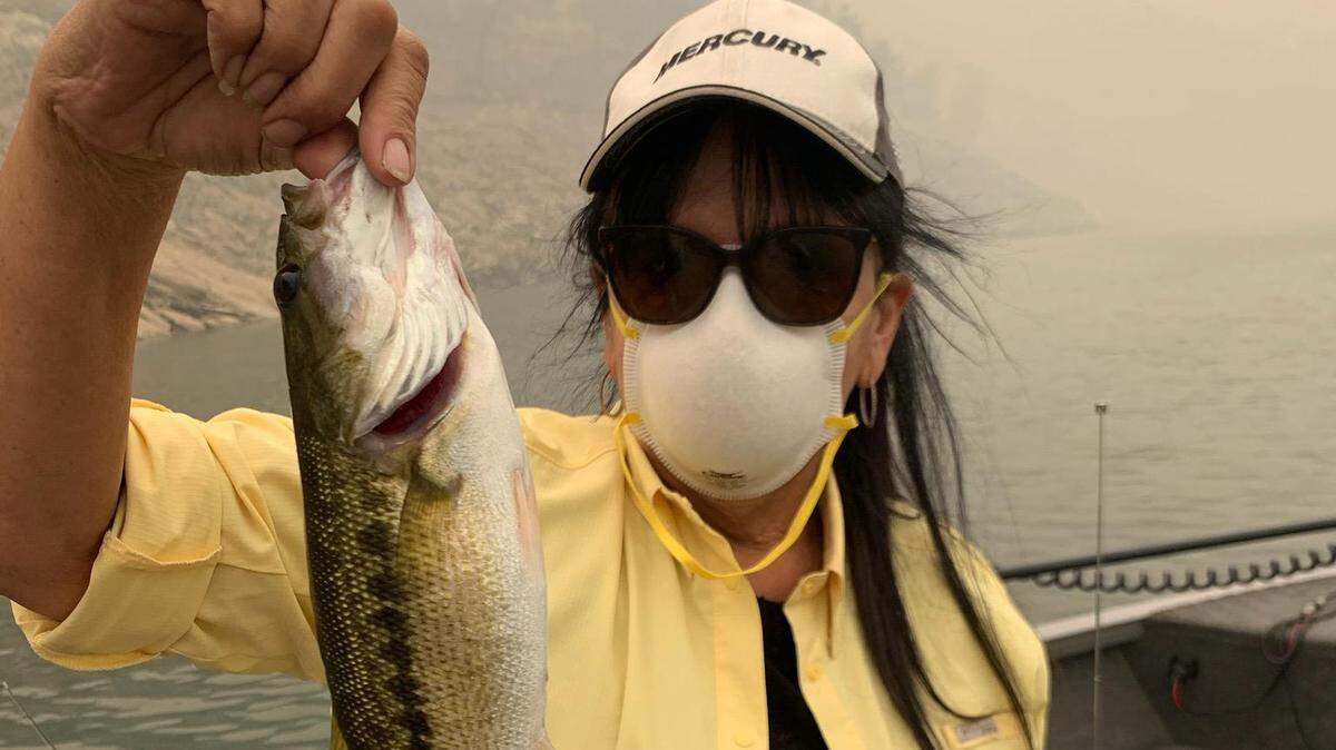 Diana Schmidt shows off a catch Sept. 12 at Millerton Lake. Her husband, Randy Schmidt, writes, “The farther up river, the more smoke we were in. At some areas we couldn’t see the banks ... four hours is all I could do with an N95 mask.”