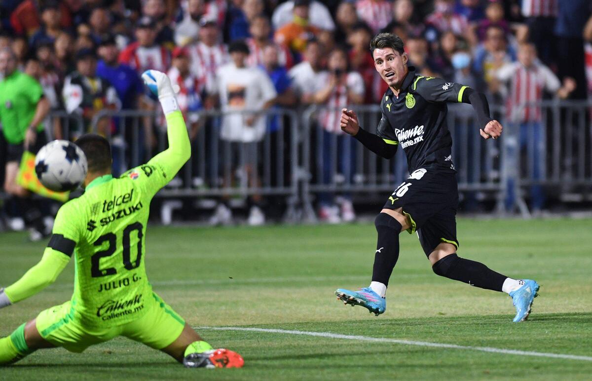 Chivas de Guadalajara’s Cristian Calderon, right, watches as his kick sends the ball past Pumas UNAM’s goalkeeper Julio Gonzalez, left, for the first goal of the night Wednesday, March 23, 2022 in Fresno.