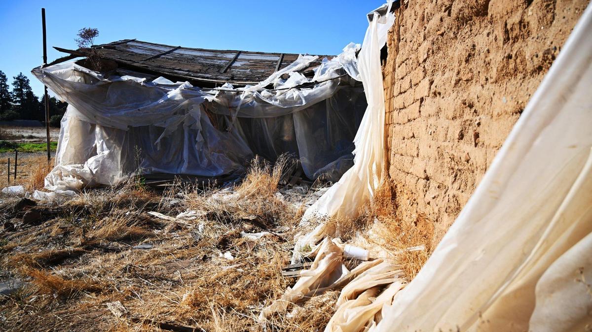 The historic Jose Garcia Adobe sits wrapped in tattered plastic on land south of Shaw Ave. within view of Island Waterpark just to the north. Photographed Tuesday, Nov. 28, 2023 in Fresno.