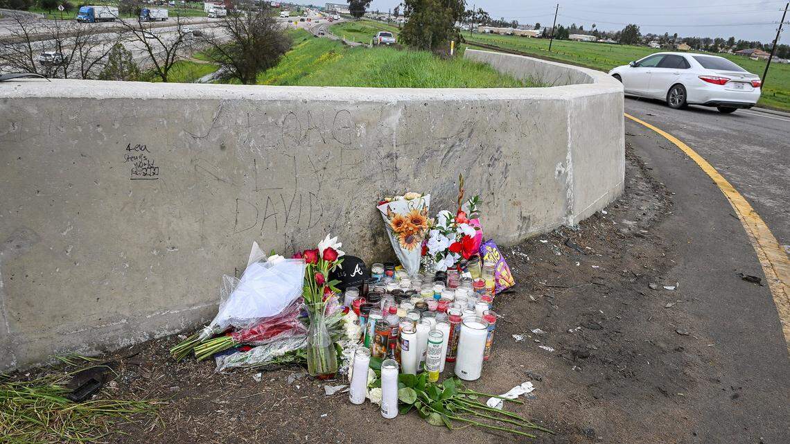 A memorial with candles and flowers has been appears on Tuesday, Feb. 17, 2026 at the site of a crash that killed four people early Sunday morning near the freeway onramp at Highway 99 and Avenue 17 in Madera County.
