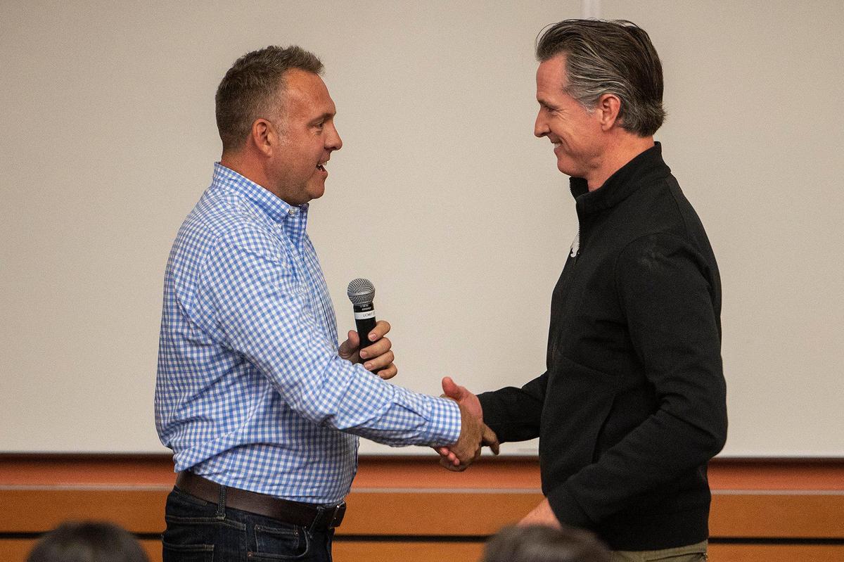 California Gov. Gavin Newsom, right, shakes hands with Assemblymember Adam Gray, left, while visiting a government class taught by Gray and University of California, Merced political science professor Nathan Monroe, on the campus of UC Merced in Merced, Calif., on Monday, Nov. 7, 2022.