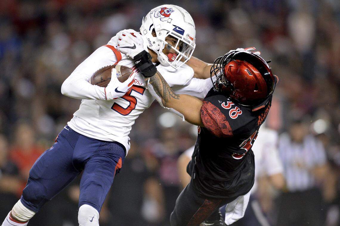 Fresno State wide receiver Jalen Cropper, left, is tackled by San Diego State linebacker Andrew Aleki during the first half Friday night. Cropper left the game after the play, returning to the sideline in the second half on crutches with a brace on his left knee.