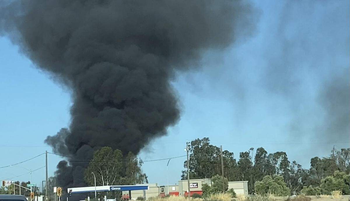 A tower of black smoke erupts Tuesday evening after a fast-moving blaze erupted in northwest Fresno.