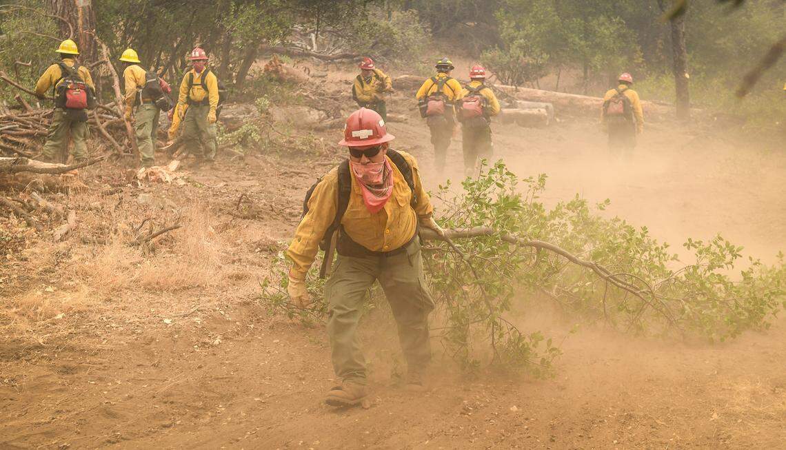 A fire crew clears brush and dried fuels while working to construct a fire break line in the Cascadel Woods area east of North Fork on Thursday, Sept. 10, 2020. The weather has helped with the firefighting efforts on the Creek Fire with far less wind and an inversion layer calming down fire activity.