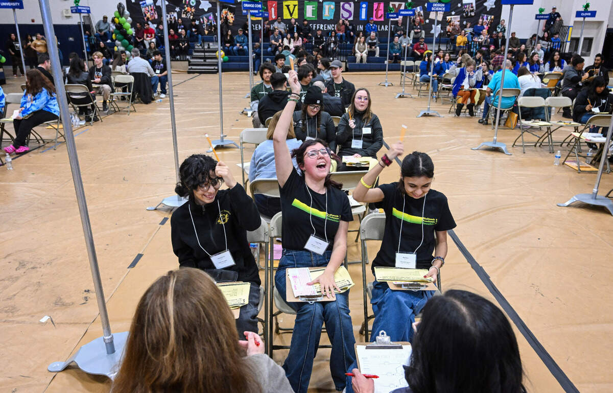 Hallmark Academy’s Trisidy Florez, center, celebrates a correct answer with her Academic Decathlon teammates Desirae Gomez, left, and Ellie Florez during the Super Quiz portion of the 42nd annual Fresno County Academic Decathlon at Sunnyside High School on Saturday, Feb. 3 2024.