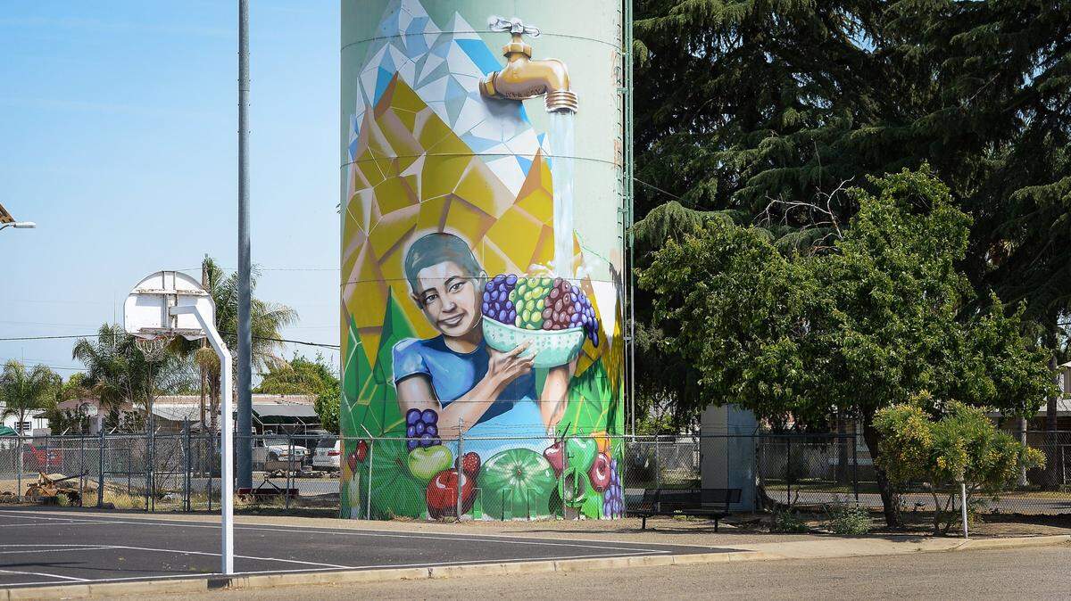 A mural on a water tower in Poplar depicts water flowing out of a faucet onto a bowl of grapes held by a child. Water is in short supply for both farms and cities in this current drought year.