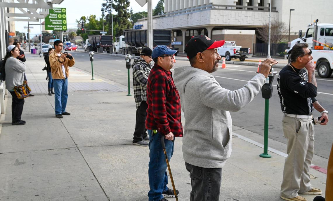 A few onlookers watch as the Guarantee Bank G sign is finally removed from the Guarantee Bank building, owned by the State Center Community College District, on Saturday, Feb. 3, 2024.