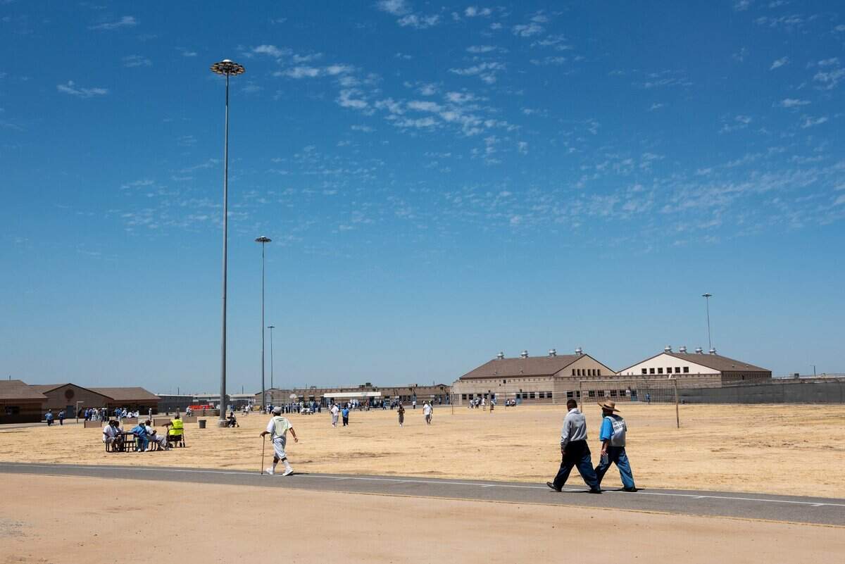 Inmates walk across the grounds of Valley State Prison in Chowchilla, Calif., on Tuesday, July 27, 2021.