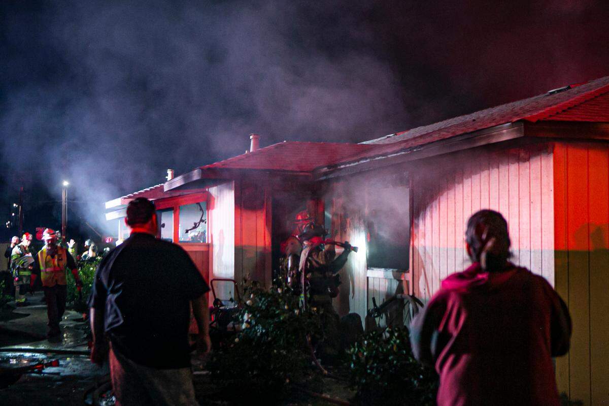 Crews work to fully extinguish flames after a two-alarm fire broke out Friday Nov. 26, 2021, in one unit of a fourplex in central Fresno, California.