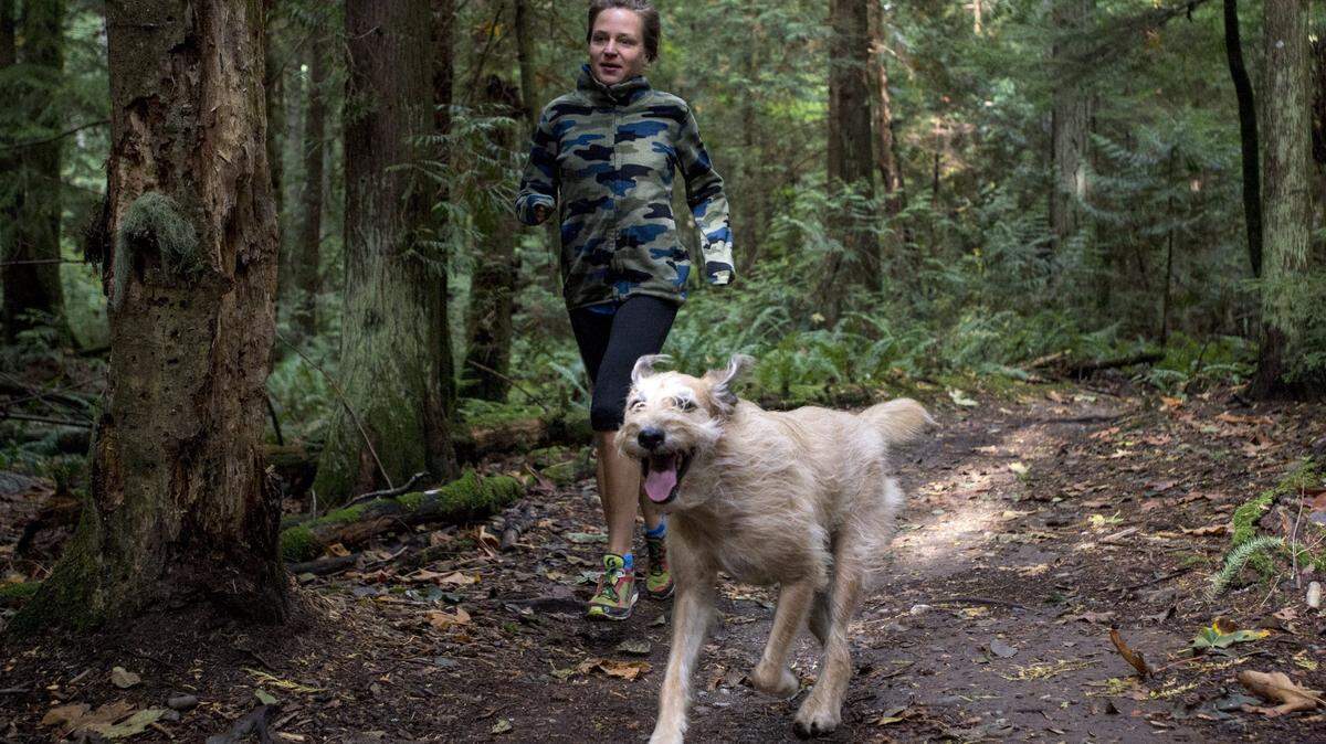 Jodee Adams-Moore runs with her dog Pablo at Lake Padden Park in preparation for the Padden Trail Half Marathon on Thursday, Oct. 17, 2014.
