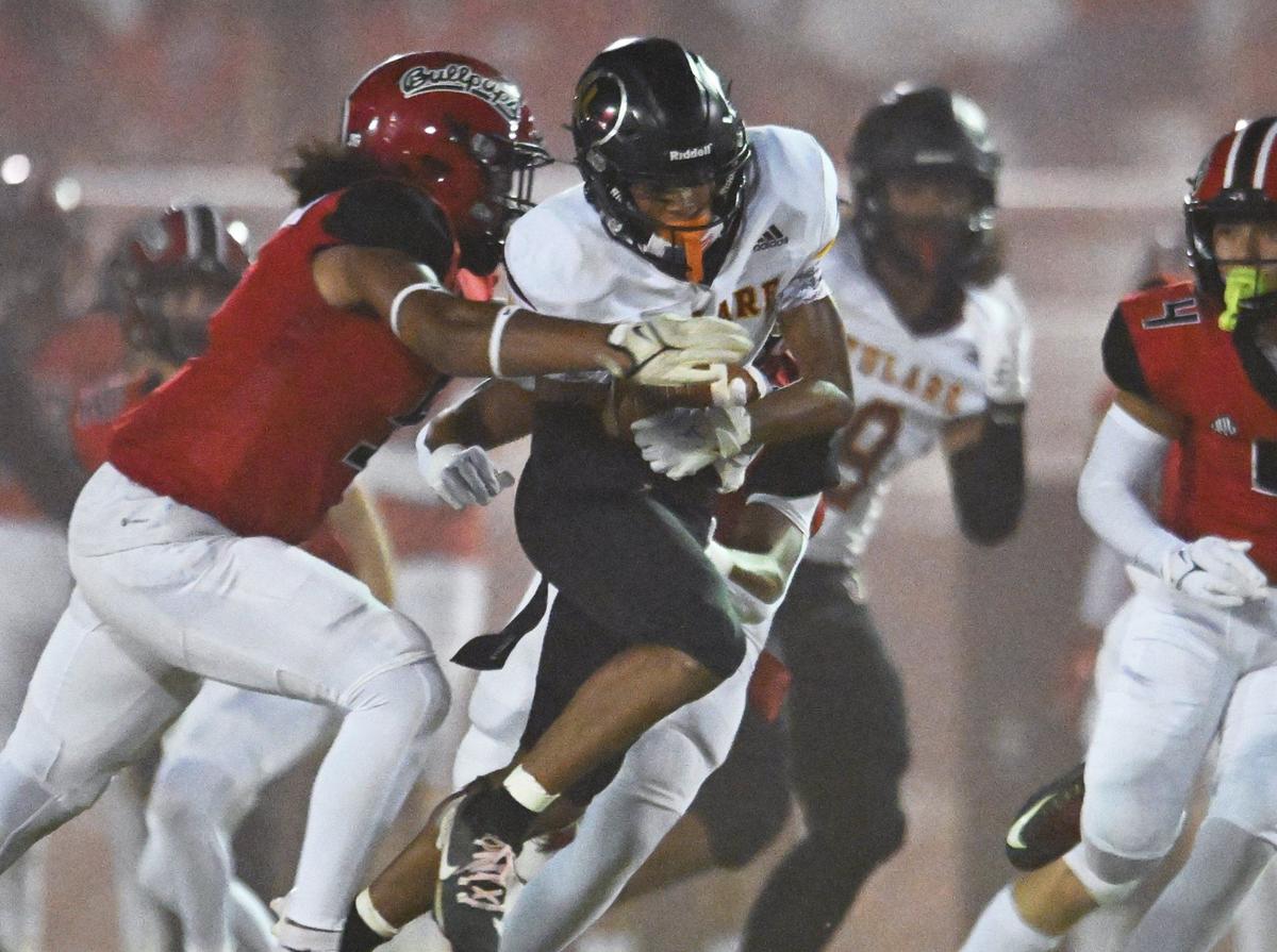 Hanford’s Justin Clark-Strickland III, left, tackles Tulare Union’s Demaje Riley after Riley intercepted a Hanford pass in first half action Friday, Oct. 11, 2024 in Hanford.