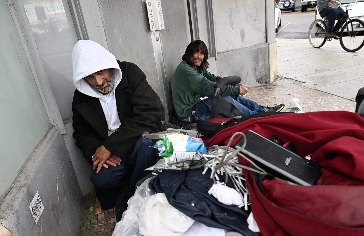 Two homeless men take shelter from the rain in a doorway in Fresno's Chinatown Wednesday morning, Dec 24, 2025 in Fresno.