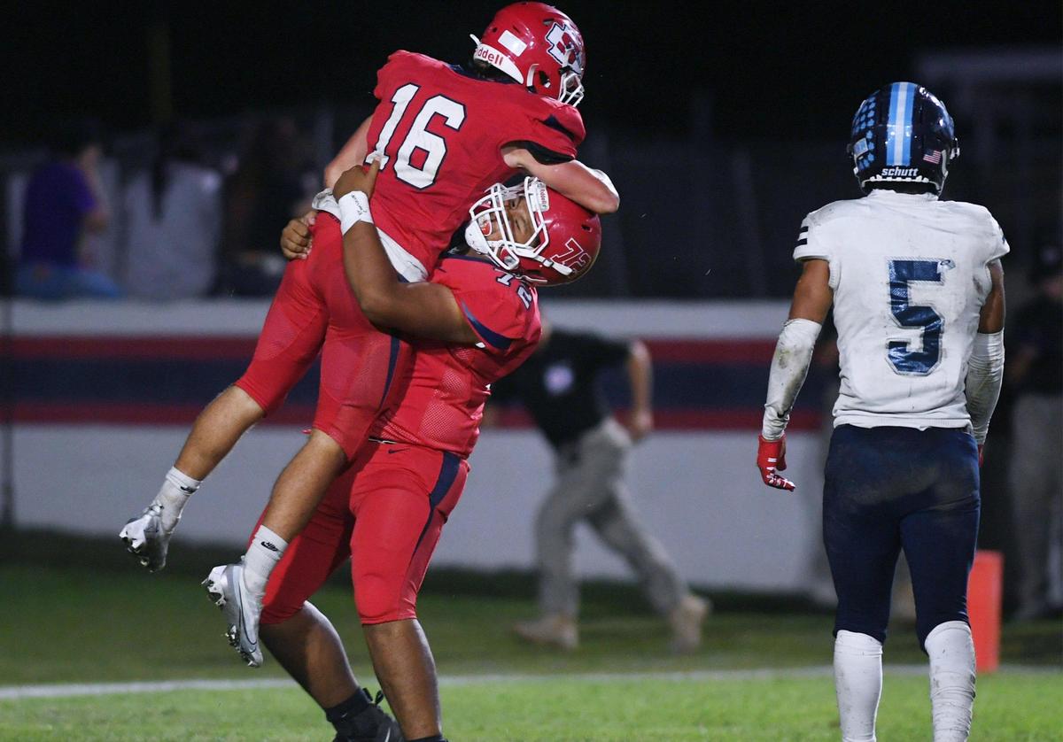 Sanger’s Marshall Pittman, left, is raised in triumph after he scores the last touchdown of the game with a dejected Eddie Torres of Bullard, right, walking away at Tom Flores Stadium Friday, Oct. 21, 2022 in Sanger.