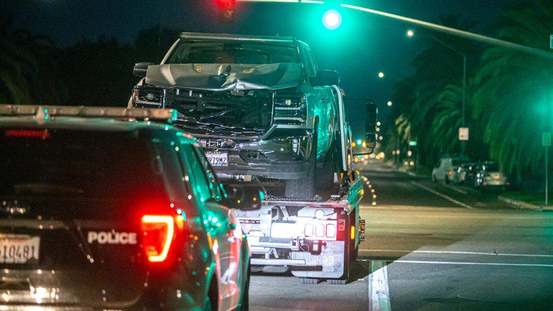 Officers escort a tow truck carrying a truck involved in a fatal hit-and-run out of an apartment complex on Friday, May 13, 2022. The driver of the truck hit and killed a 29-year-old woman, dragging her 8 miles through Fresno.