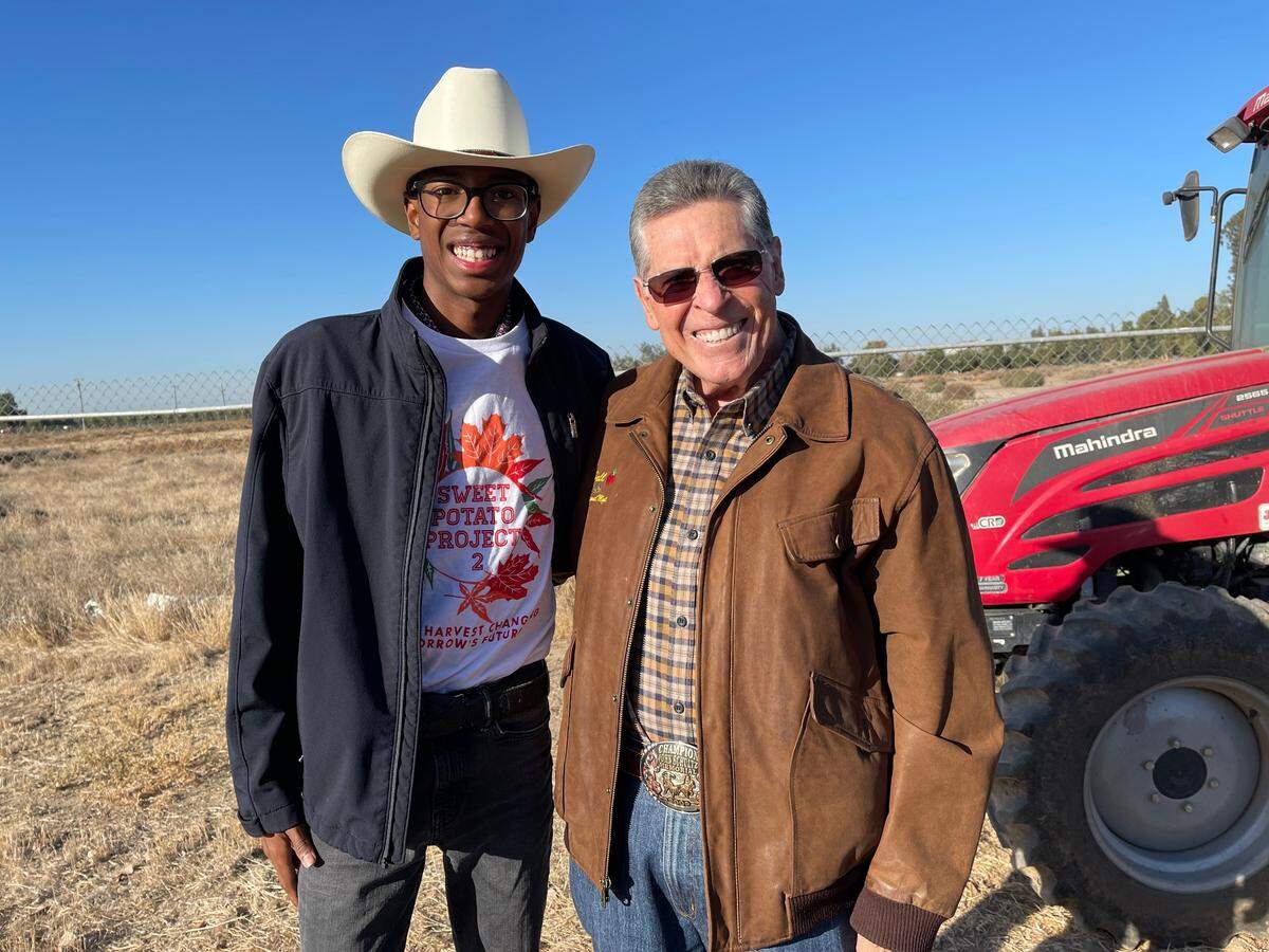 Sweet Potato Project participant, Jay-Lynn Rodriguez with Earl Hall, owner of Hall Management Corp., near a tractor donated by Hall, during the Sweet Potato harvest, Saturday, Oct. 29, 2022.