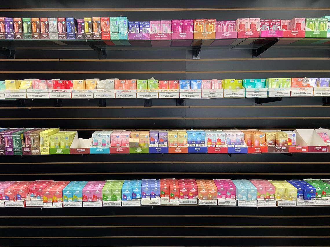 Rows of flavored tobacco vape juice, including varieties banned by Proposition 31, are displayed on the wall of a central Fresno smoke shop as seen on Oct. 18, 2023.