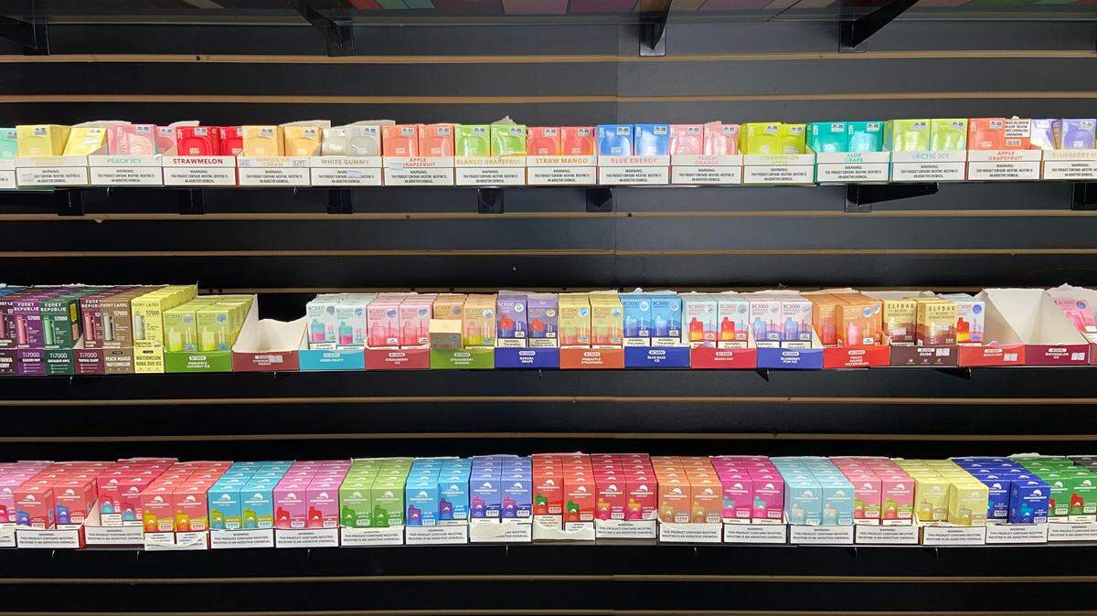 Rows of flavored tobacco vape juice, including varieties banned by Proposition 31, are displayed on the wall of a central Fresno smoke shop as seen on Oct. 18, 2023. A new study found that Californians appear to evading the ban through e-commerce.