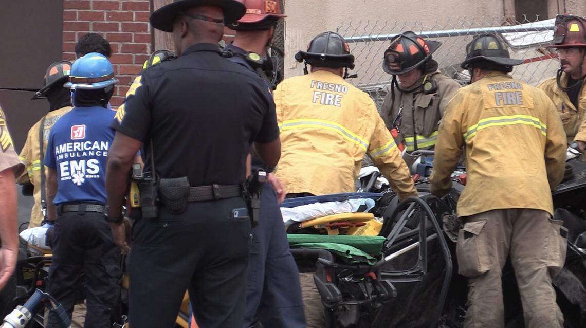 The Fresno Fire Department work to extricate a suspect who ran a red light and crashed into a power pole and a fire hydrant on Saturday, Sept. 10, 2022.