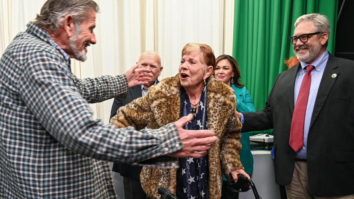 Sally Caglia, center, gets a hug from her brother Vince Caglia, left, as Fresno Chamber of Commerce CEO Scott Miller, right, watches after announcing Sally as the 2023 Leon S. Peters Award recipient in front of family and friends at CMAC in Fresno on Tuesday, Jan. 17, 2023.