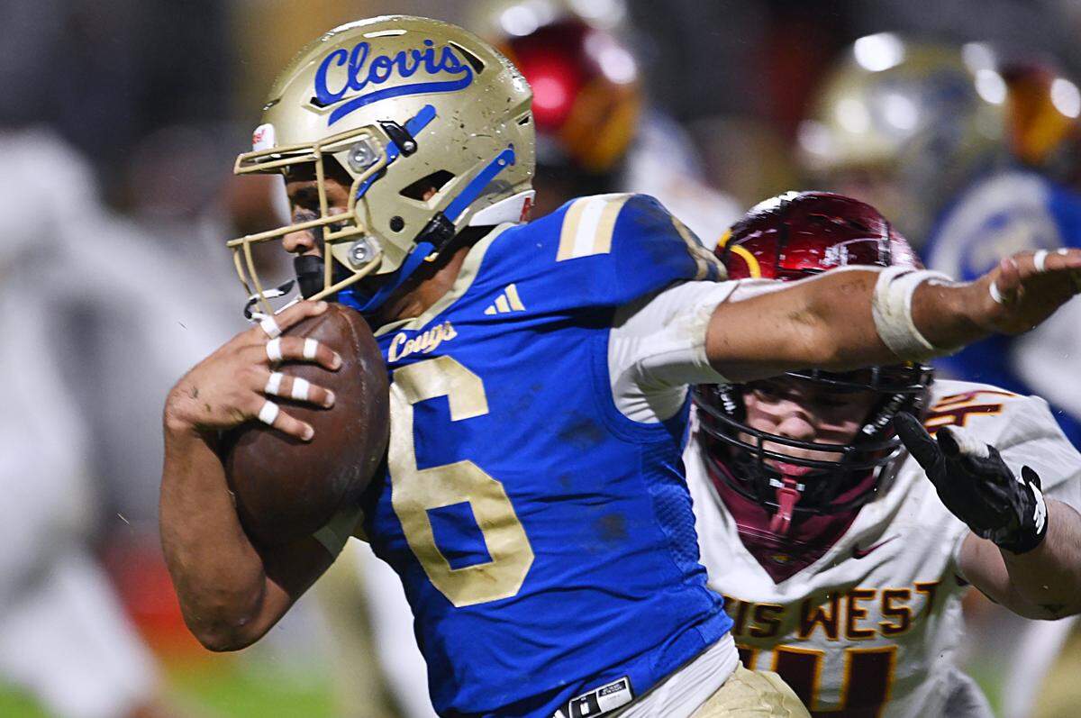 Clovis High's James Curoso, left, runs past Clovis West's Logan Vogt, background right, Friday, Nov. 14, 2025 in Clovis. Clovis led 21-7 at halftime.