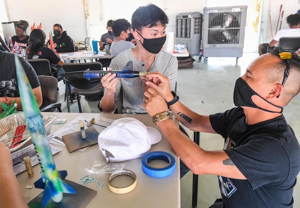 High school aviation camp teacher Krishnna Reyes, right, helps student Calvin Thao with his rocket while working in the summer camp class at Chandler Executive Airport in Fresno on Tuesday, June 15, 2021.