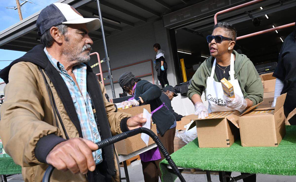Wanda Parrish, right, asks a man if he wants what she’s distributing during a food bank event held at Saint Rest Baptist Church Thursday, Nov. 6, 2025 in West Fresno.