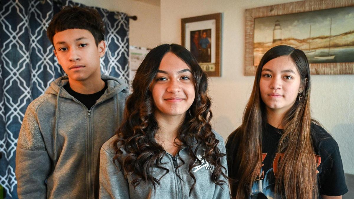 Jayvian Her, 13, stands with his sisters Jasalyn Her, 12, center, and Jaytan Her, 15, at their home in west Fresno on Tuesday, Dec. 14, 2021. The siblings were detained by CHP and Fresno police officers after video recording an arrest.