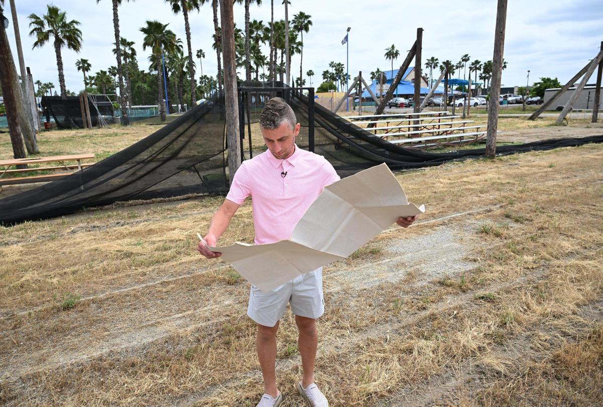 Brian Easler, President of Fuego FC, stands on the former paintball field where a new soccer stadium is planned while looking over a map showing the Blackbeard’s Family Entertainment Center property Thursday, April 17, 2025 in Fresno.