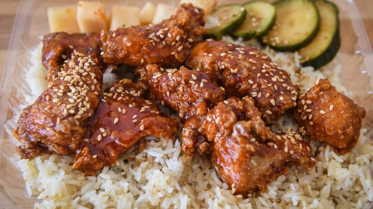 Un plato de arroz con ajo y cebollín con alitas de pollo asiáticas sin hueso de Pacific Fried Chicken, un restaurante local del sureste de Fresno.
