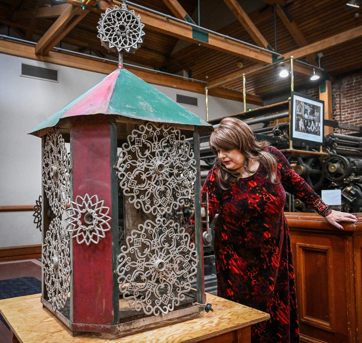 Elizabeth Laval, president of the Fresno City & County Historical Society, takes a close look at one of the 82 lanterns found earlier this year by CalTrans workers building the California High-Speed Rail project through Fresno, during a press conference at The Archive on Kern on Friday, Dec. 19, 2025.
