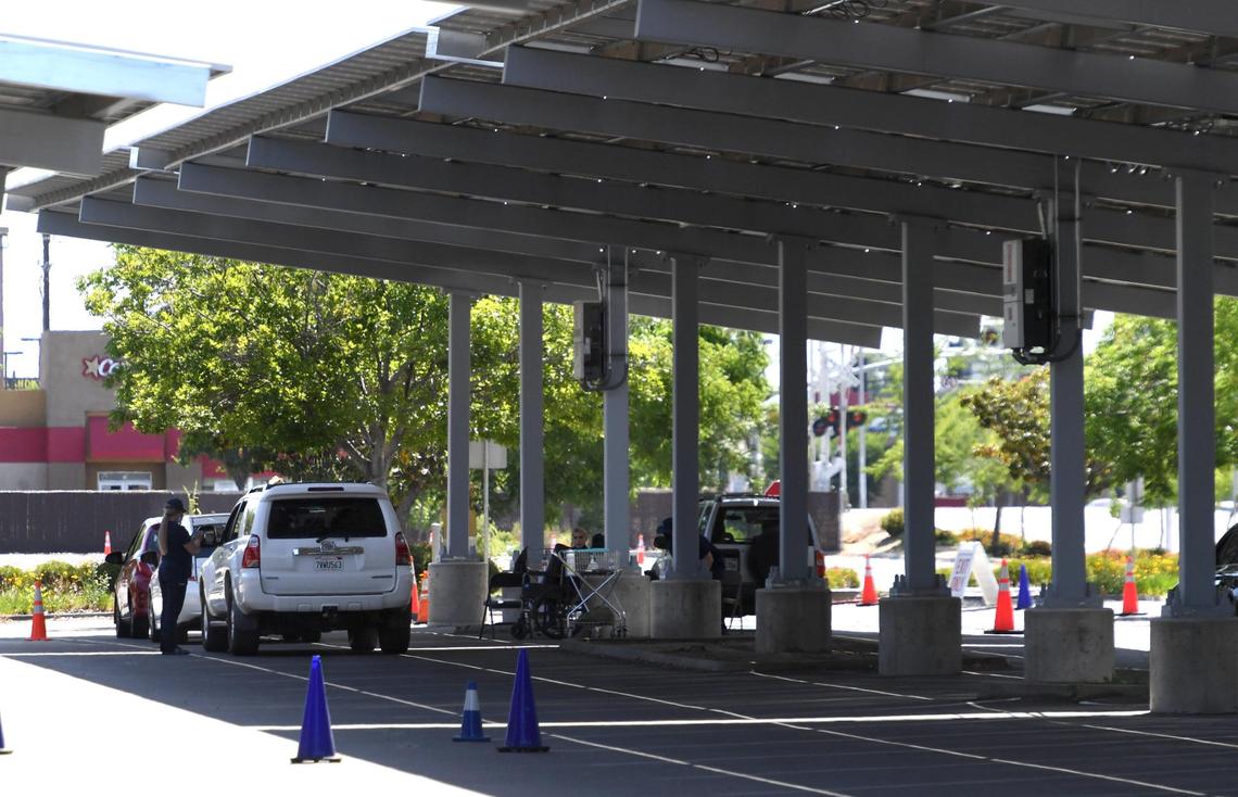 A few cars, with vaccine recipients waiting their 15 minutes, sit in the shade at the UCSF Covid Equity Project drive-up clinic at Fresno City College, Friday May 7, 2021.
