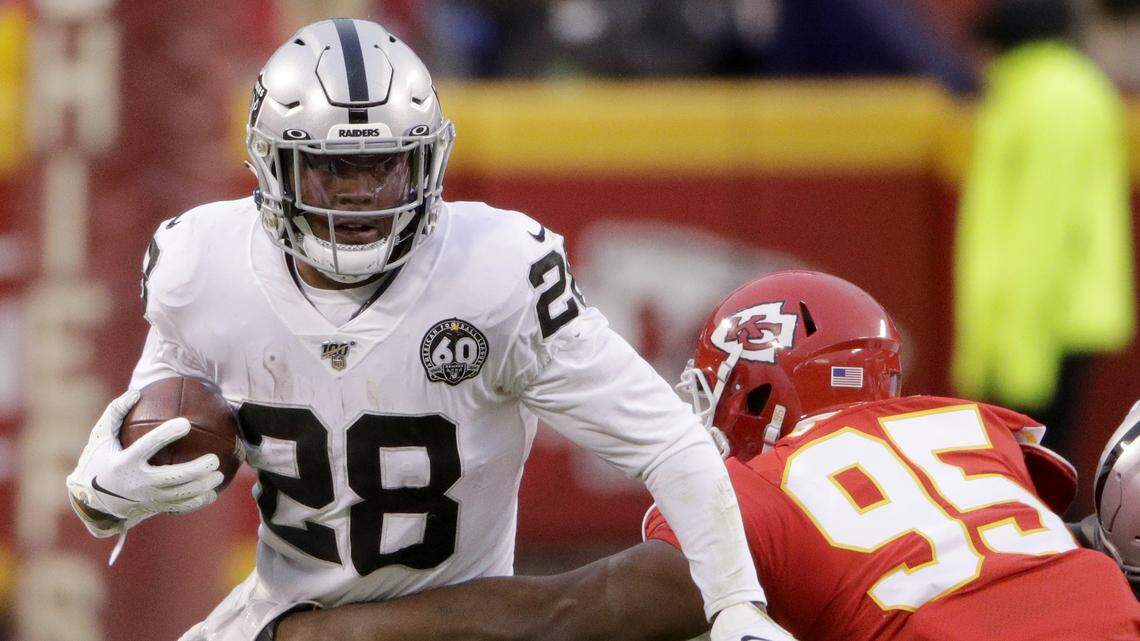 Oakland Raiders running back Josh Jacobs (28) tries to break a tackle by Kansas City Chiefs defensive tackle Chris Jones (95) during the first half of an NFL football game in Kansas City, Mo., Sunday, Dec. 1, 2019.
