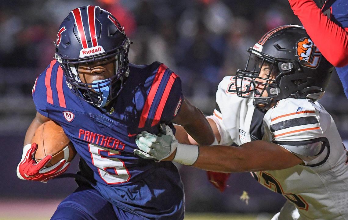 Memorial’s Donovan Harris, left, tries to free himself from the grasp of Central’s Caleb Shelton in the first half of their quarterfinal playoff game at San Joaquin Memorial on Thursday, Nov. 10, 2022.