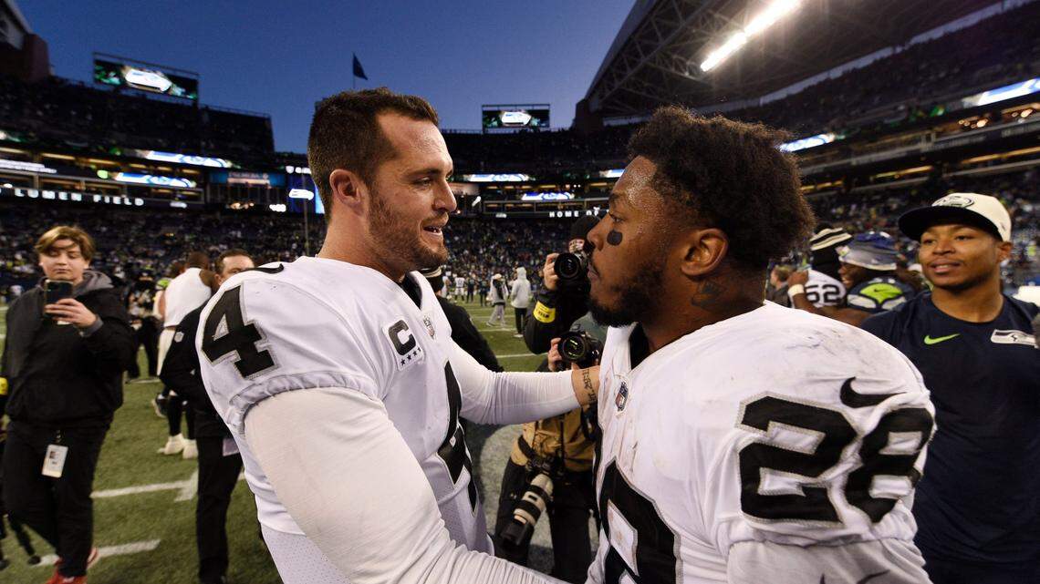 Las Vegas Raiders quarterback Derek Carr (4) celebrates with running back Josh Jacobs after an overtime win over the Seattle Seahawks during an NFL game Sunday, Nov. 27, 2022, in Seattle.
