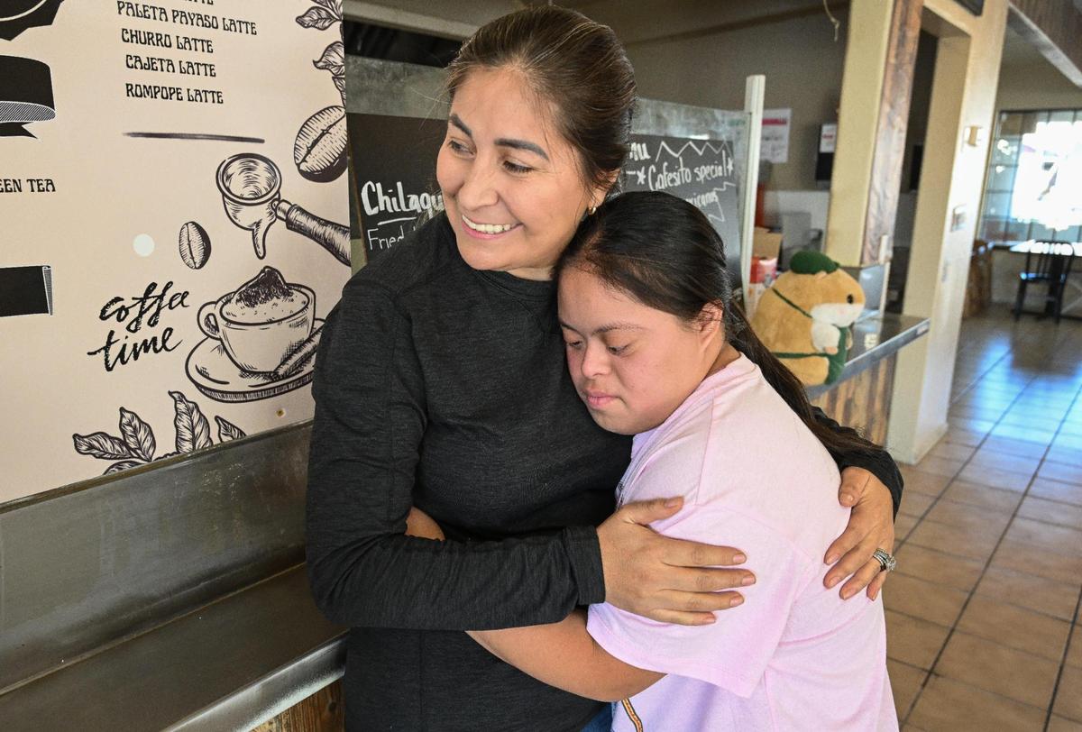 Evelyn Gutiérrez-Macedo, propietaria de Mi Cafesito, abraza a su sobrina, Diana Gutiérrez, mientras se encuentra en el nuevo local del café en las avenidas Van Ness y Home en el Tower District.