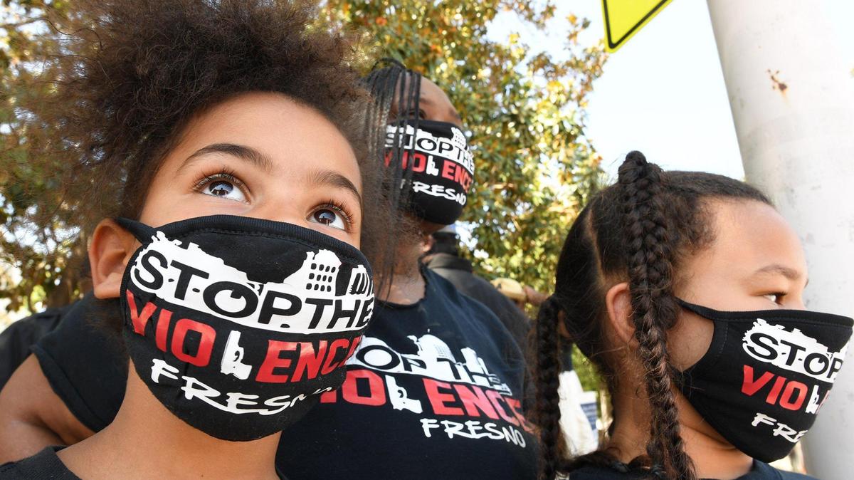 Sisters Grace Golden, 7, left, and Saraya Golden, 8, with their grandmother Rolinda Golden, center, take in the Black Lives Matter Annual Proclamation and Street Art Event in front of city hall, June 18, 2020.