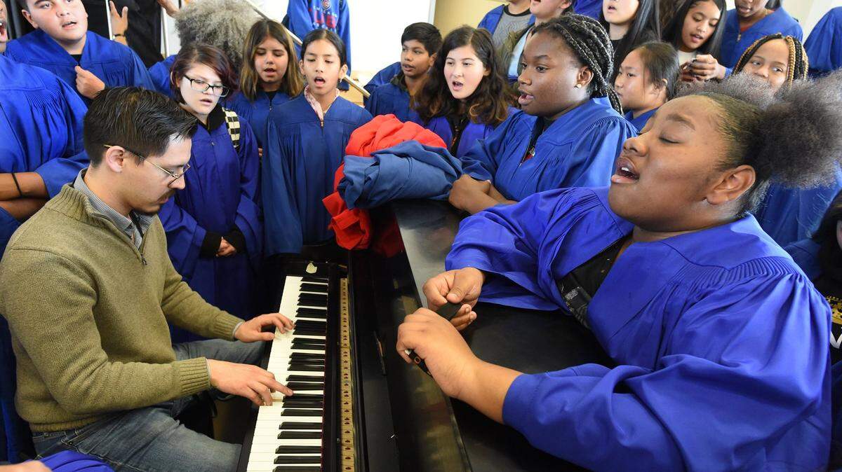 Gaston Middle School Choir members gather around director E.J. Hinojosa as they practice a song in celebration of Black History Month in February 2020.