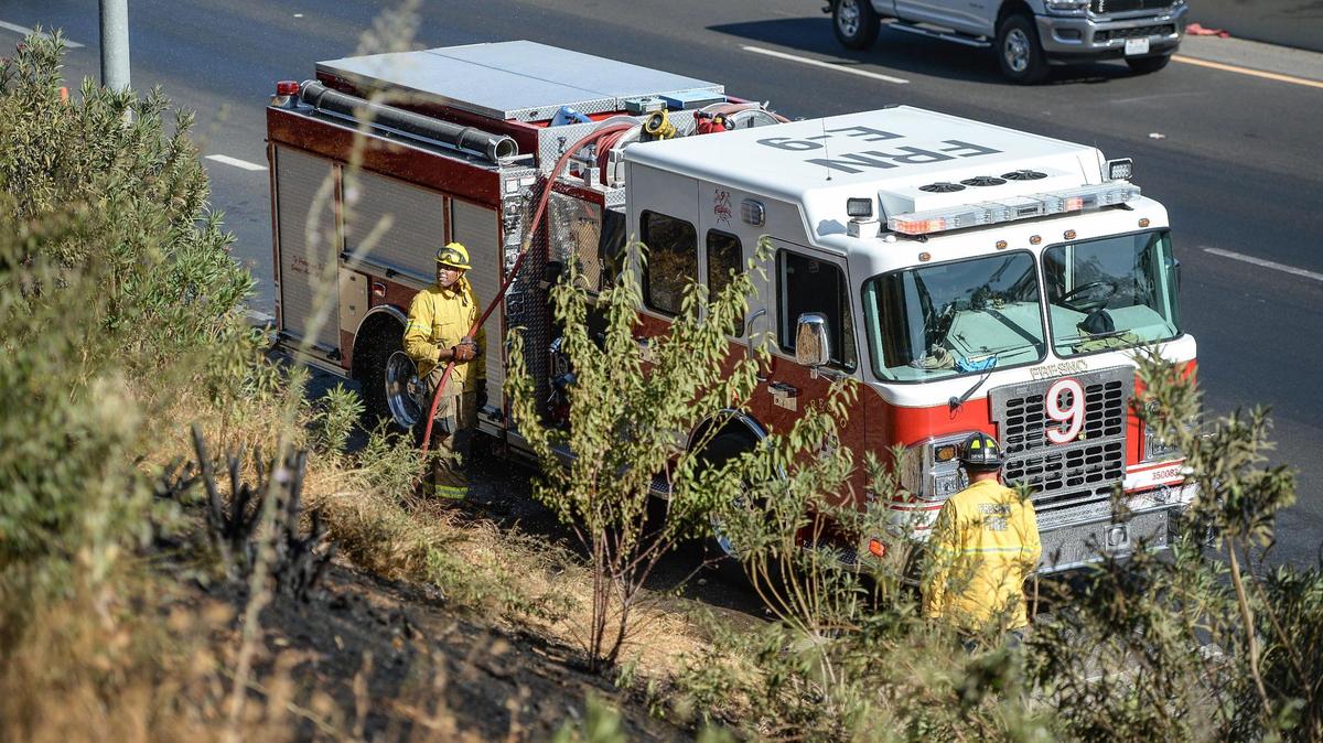 Fresno firefighters finish mopping up a grass fire on the side of Highway 99 at Belmont Avenue on Wednesday, Sept. 29, 2021.