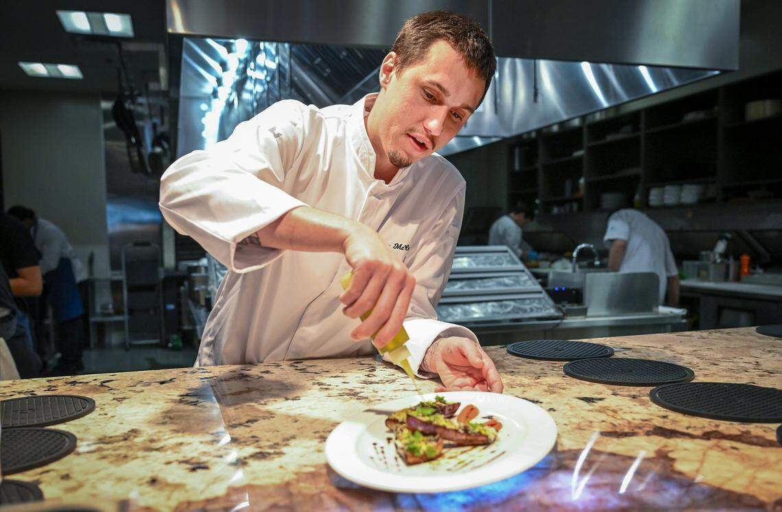 Chef Max McCarthy puts the finishing touches on a fire-roasted eggplant dish at Bulle in Northwest Fresno on Tuesday, April 21, 2026.