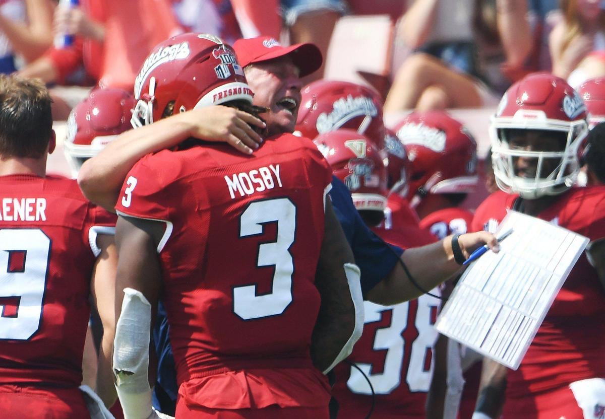 Fresno State’s Kalen DeBoer, right, congratulates Arron Mosby’s touchdown after a fumble recovery against UConn Saturday, Aug. 28, 2021 in Fresno. The Bulldogs led 31-0 at halftime.