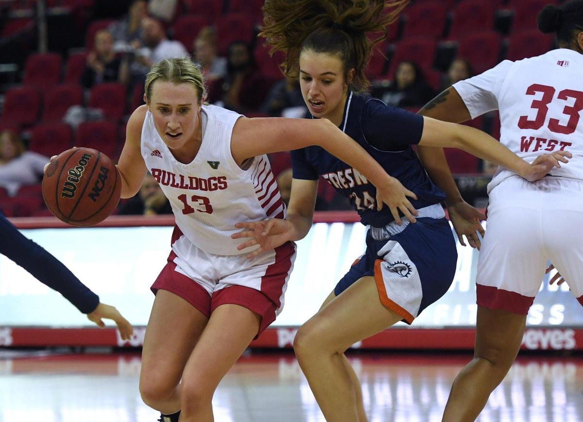Fresno State’s Amiee Book, left, drives past Fresno Pacific’s Jenna Kurz, center, Monday, Nov. 7, 2022 in Fresno.