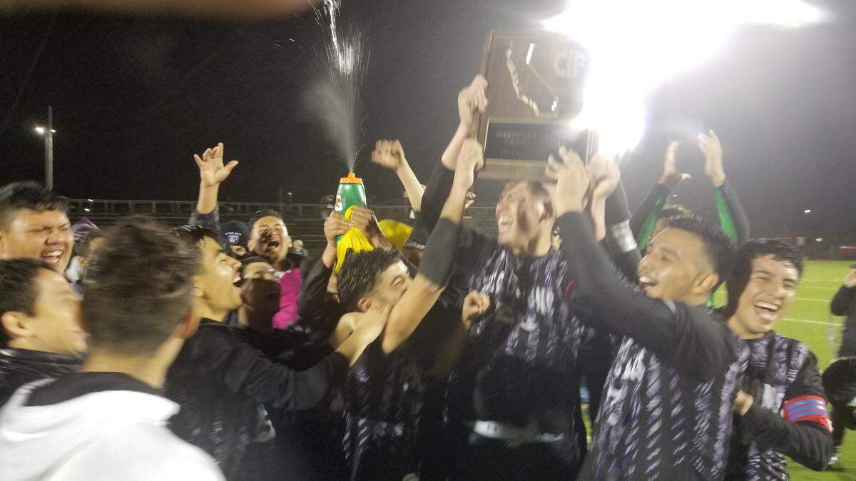 Madera South High boys soccer players celebrate with their Northern California Division III championship plaque after beating Sacred Heart Cathedral Prep-San Francisco 4-2 in the final Saturday night, March 2, 2019 in Madera.