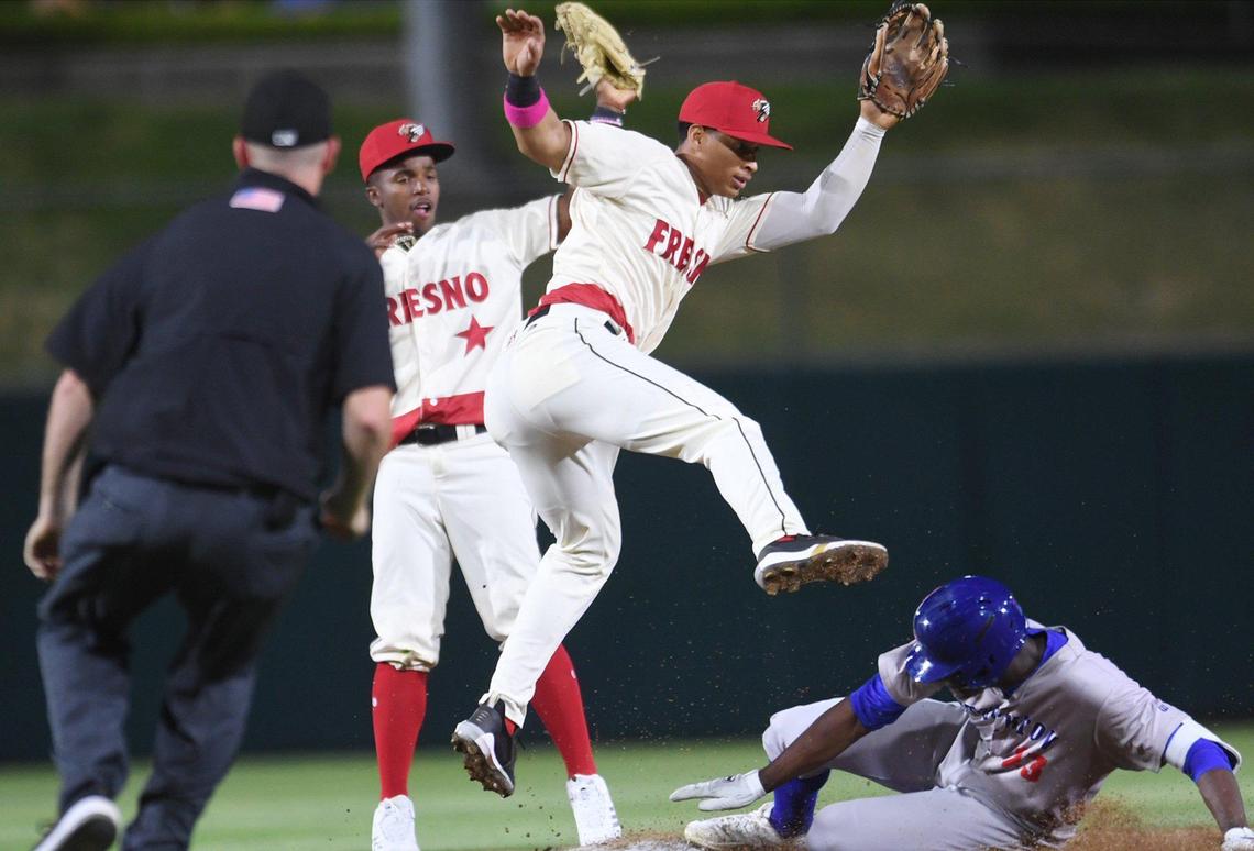 Stockton Ports’ Denzel Clarke, bottom right, slide to second safely covered by Juan Brito, center, Friday, April 8, 2022 at Chukchansi Park in Fresno.