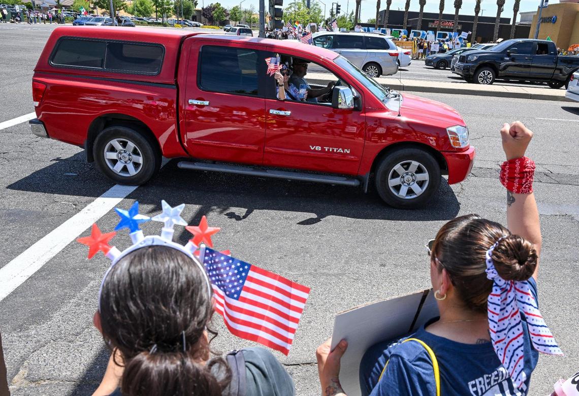 Protesters cheer on supporters driving by on Blackstone Avenue at Nees near River Park shopping center during a no kings protest against President Donald Trump’s policies in Fresno on Saturday, June 14, 2025.