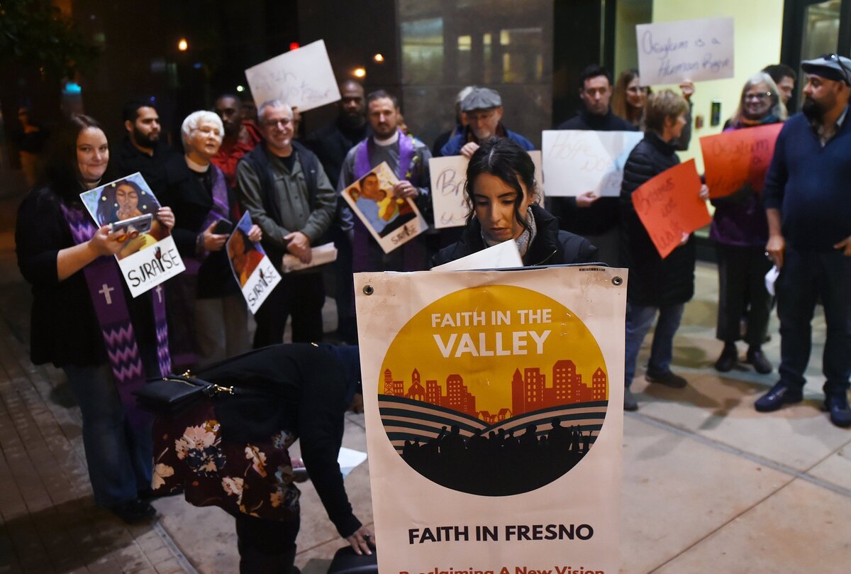 Julie Lopez, center, prepares the microphone as a crowd of 25 people gather for Faith In The Valley’s rally, decrying military action and urging politicians to protect migrants at the border Thursday, Dec. 6, 2018 in downtown Fresno