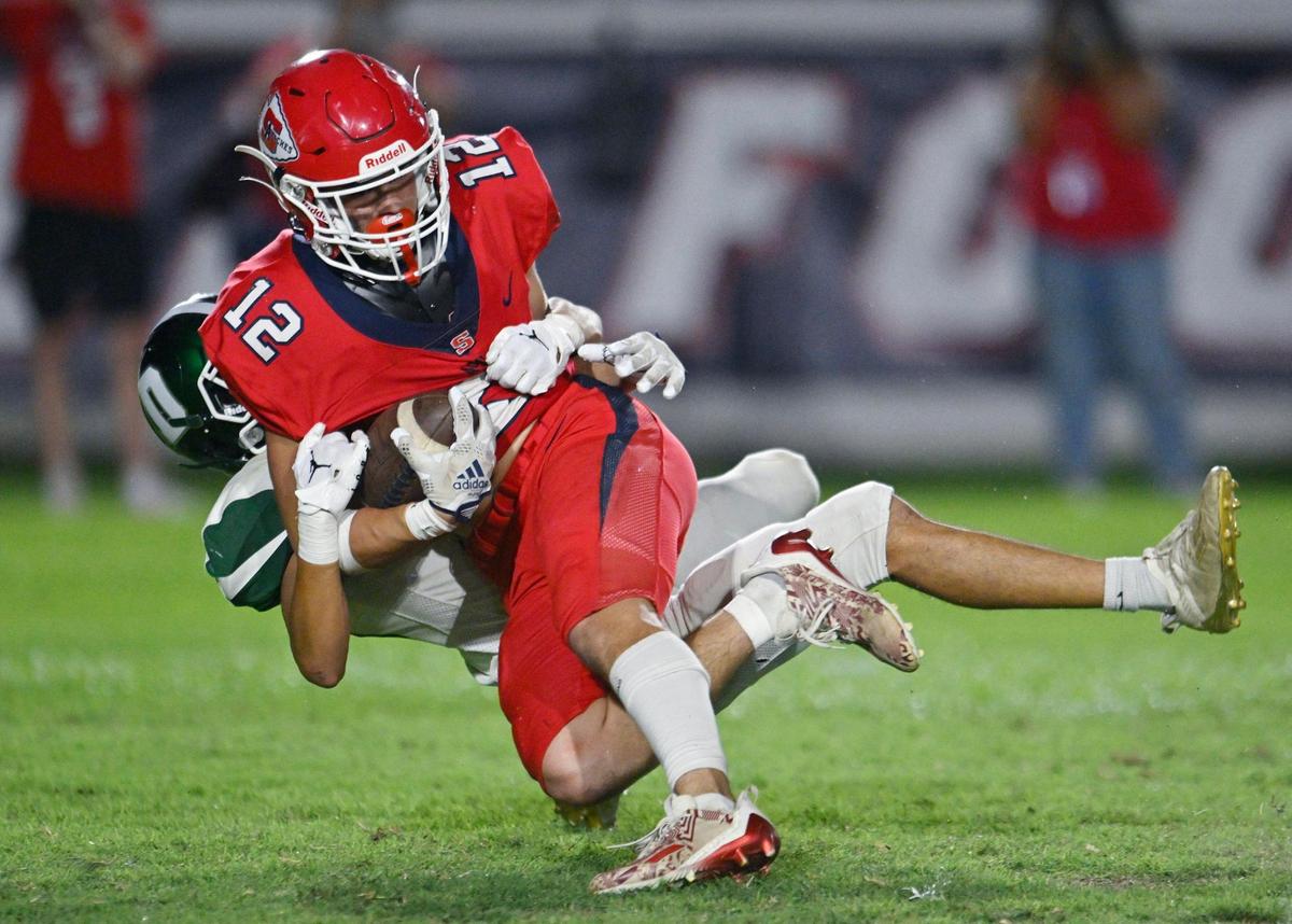 Sanger’s Tristan Conway, foreground, is brought down near the goal line by Dinuba’s Joseph Lopez in the second half Friday, Aug. 18, 2023 in Sanger. Final score, Sanger 41, Dinuba 7.