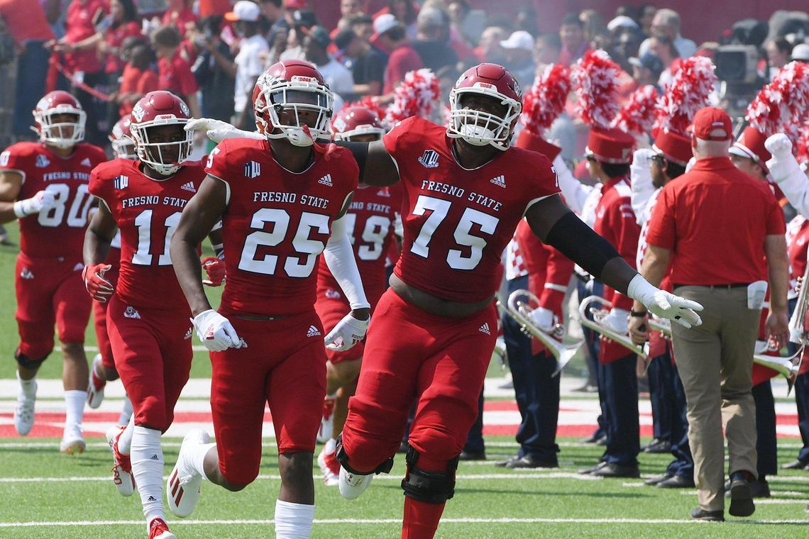 Fresno State’s Alex Akingbulu, center, spreads his arms as the Bulldogs the field against UConn Saturday, Aug. 28, 2021 in Fresno. The Bulldogs on a record-setting day won 45-0.
