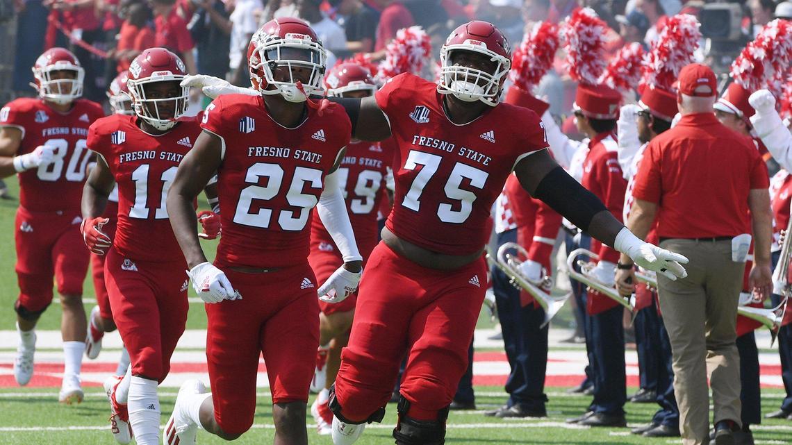 Fresno State’s Alex Akingbulu, center, spreads his arms as the Bulldogs the field against UConn Saturday, Aug. 28, 2021 in Fresno. The Bulldogs on a record-setting day won 45-0.