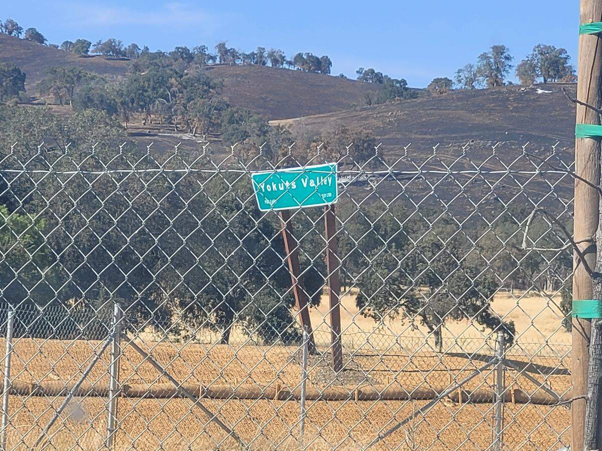 A Yokuts Valley highway sign appears to be bent and damaged in September 2024.
